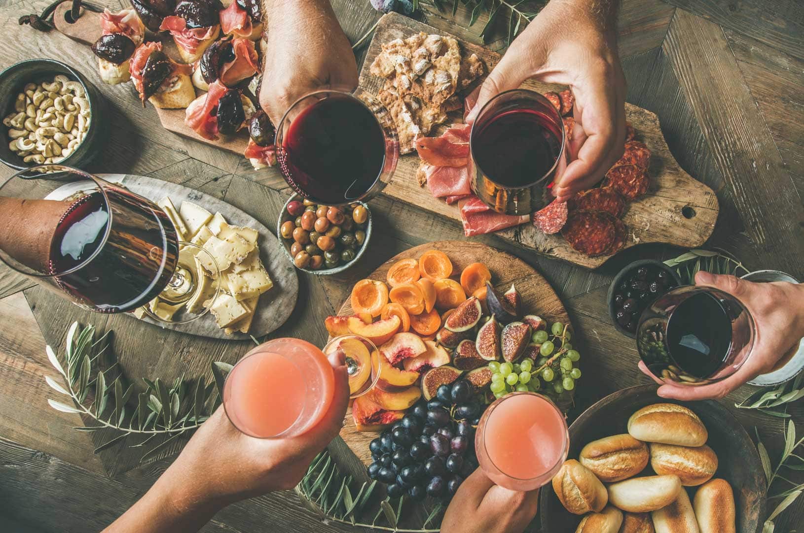 People having party sitting at table set with wine snacks